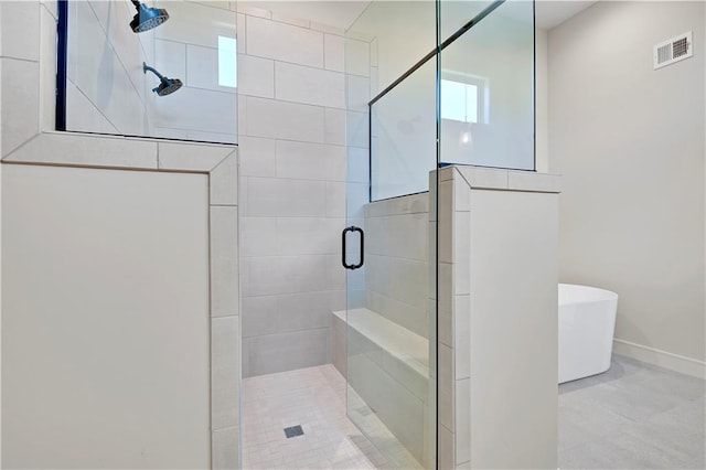 full bathroom featuring a stall shower, a freestanding tub, baseboards, and visible vents