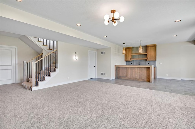 unfurnished living room featuring a chandelier, baseboards, stairway, and light colored carpet