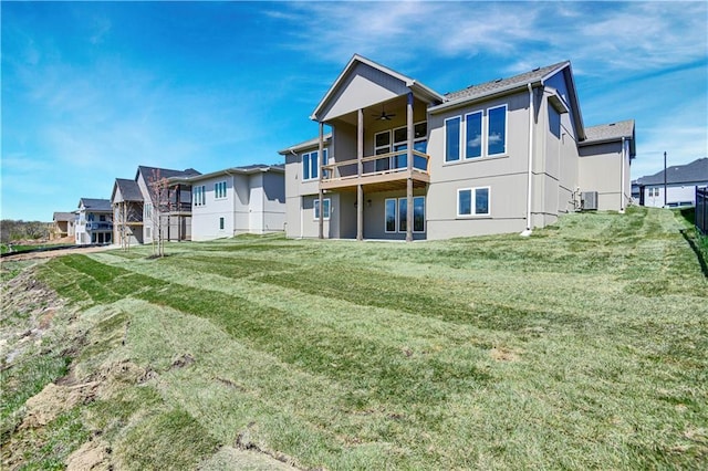 back of house featuring central AC, a ceiling fan, a residential view, and a lawn