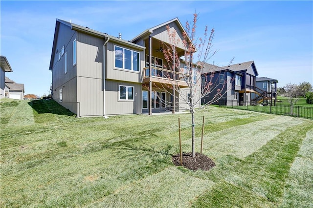 rear view of property with fence and a lawn