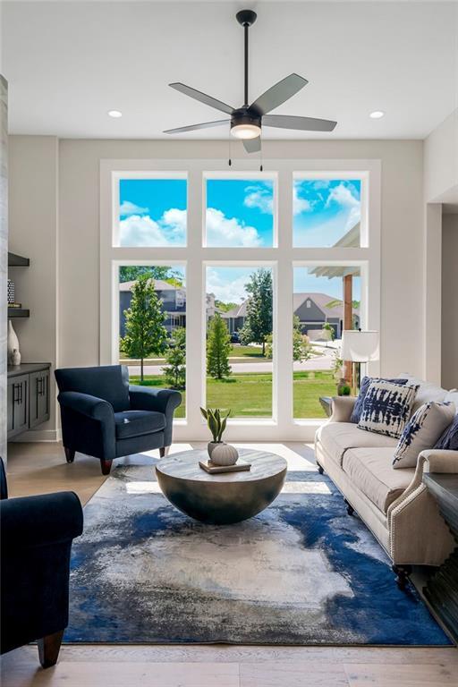 living room featuring ceiling fan and light hardwood / wood-style floors