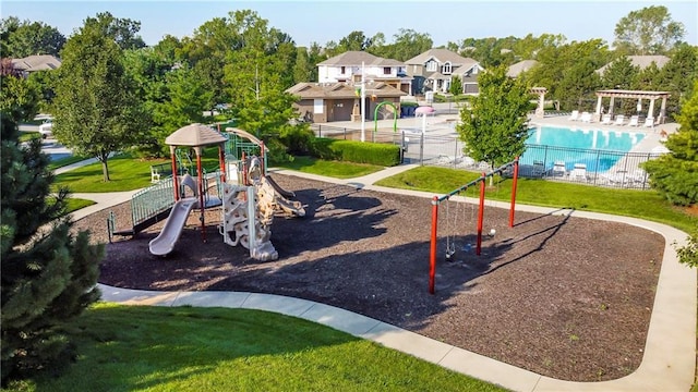 view of jungle gym featuring a community pool and a yard