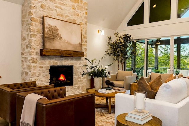 living room with high vaulted ceiling and a stone fireplace