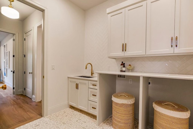 laundry area featuring light hardwood / wood-style flooring, electric dryer hookup, cabinets, and sink