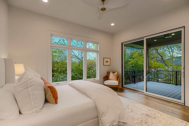 bedroom featuring multiple windows, ceiling fan, hardwood / wood-style flooring, and access to exterior