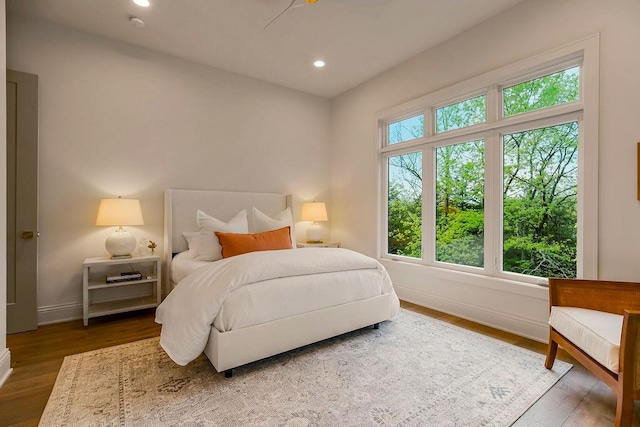 bedroom with multiple windows, ceiling fan, and dark hardwood / wood-style floors