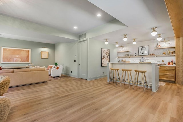 kitchen featuring a breakfast bar, kitchen peninsula, and light hardwood / wood-style flooring