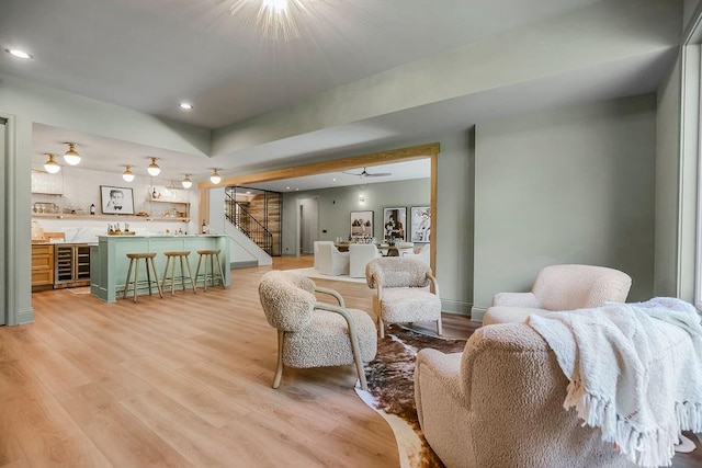 living room with light wood-type flooring, wine cooler, and ceiling fan