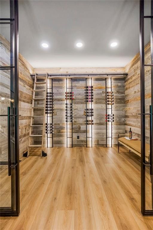 wine area with wood-type flooring and wooden walls