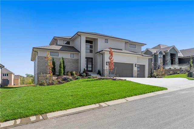 view of front of house with central AC unit, a front lawn, and a garage