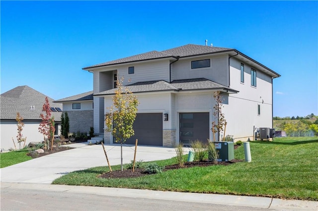 prairie-style home featuring central AC unit, a front lawn, and a garage