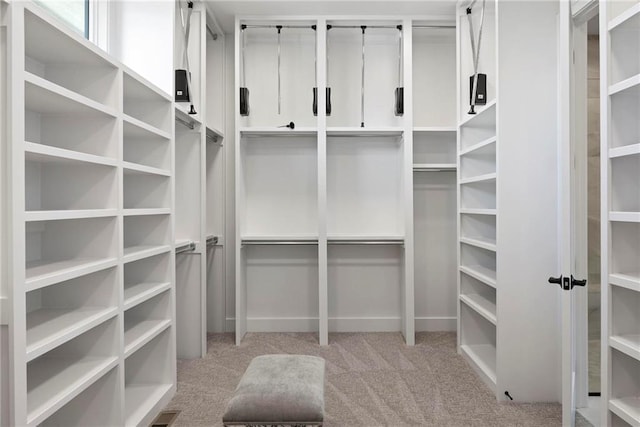 walk in closet featuring light carpet