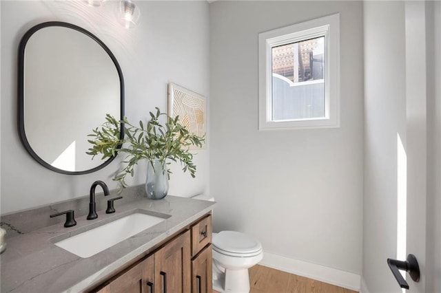 bathroom featuring toilet, hardwood / wood-style floors, and vanity