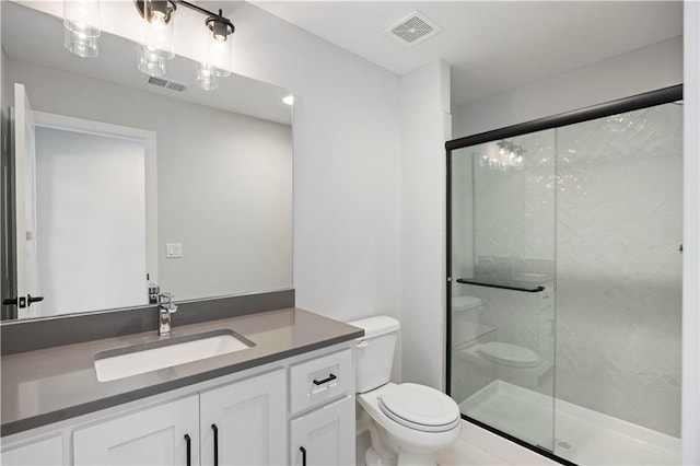 bathroom featuring a shower with shower door, large vanity, and toilet