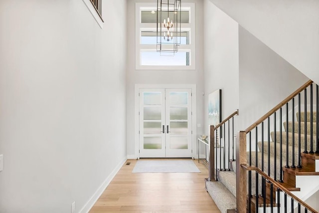 8009 Millridge St, Shawnee, KS 66220 - entryway featuring wood finished floors, a chandelier, french doors, a high ceiling, and stairs