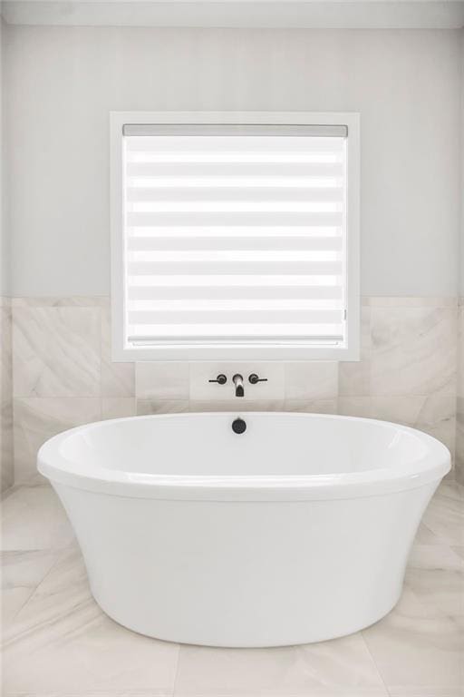 8009 Millridge St, Shawnee, KS 66220 - full bath with tile walls, a freestanding bath, a wainscoted wall, and tile patterned floors