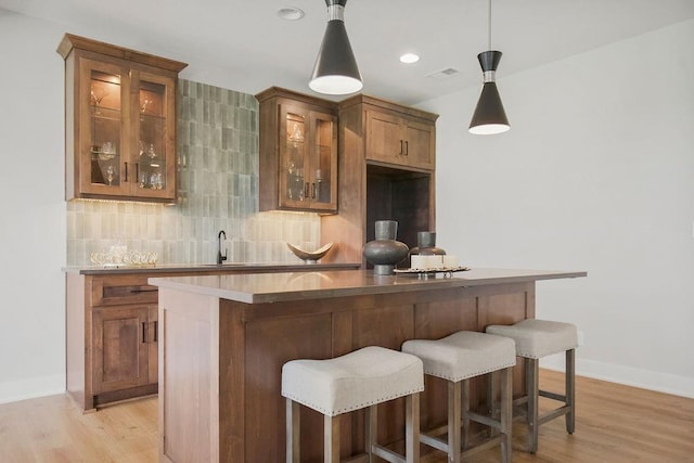 8009 Millridge St, Shawnee, KS 66220 - indoor wet bar with tasteful backsplash, light wood finished floors, and pendant lighting
