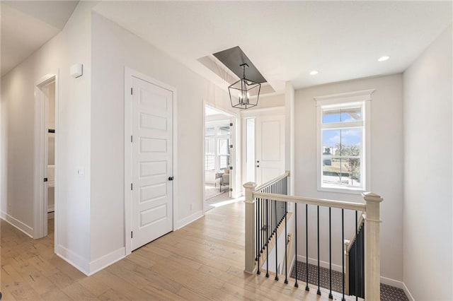 hall featuring light hardwood / wood-style flooring and a notable chandelier