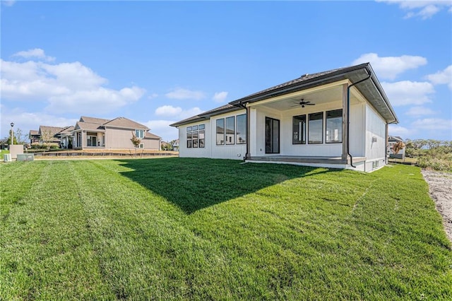 rear view of house with a yard and ceiling fan