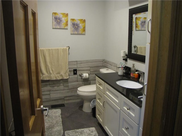 bathroom featuring tile floors, vanity, and toilet