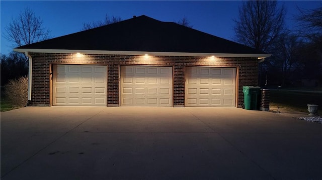 view of garage at twilight