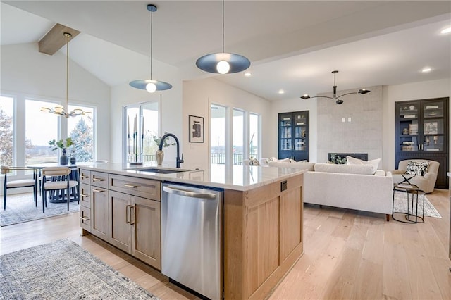 kitchen featuring stainless steel dishwasher, a kitchen island with sink, a notable chandelier, and light hardwood / wood-style floors