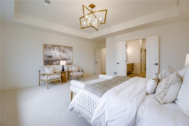 bedroom featuring light carpet, a chandelier, a raised ceiling, and connected bathroom