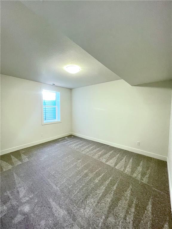 carpeted empty room featuring a textured ceiling