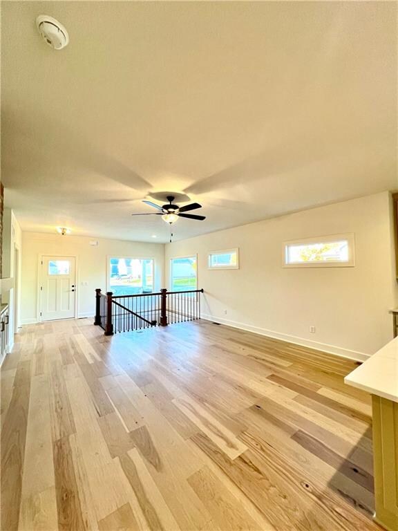 unfurnished living room with ceiling fan and light hardwood / wood-style flooring