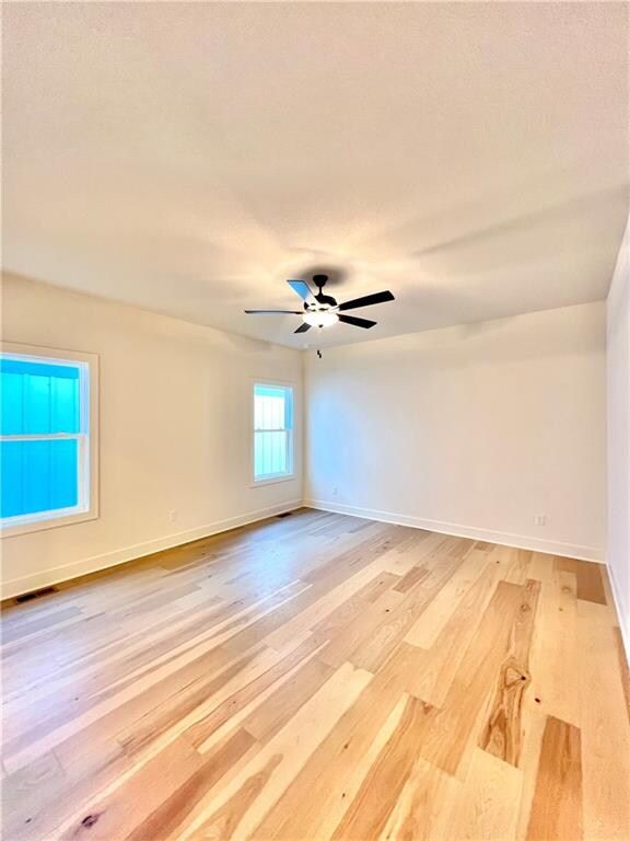 empty room with hardwood / wood-style flooring and ceiling fan