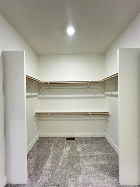 spacious closet featuring dark carpet