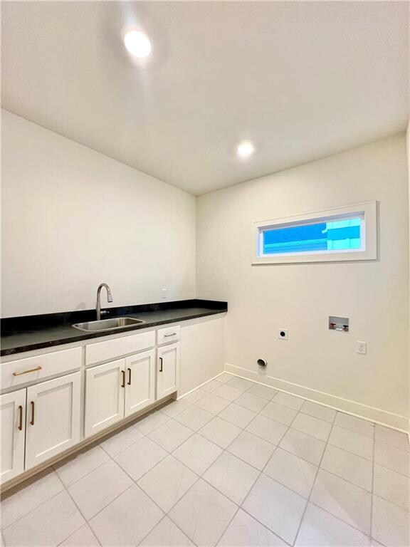 clothes washing area featuring sink, washer hookup, and light tile patterned floors