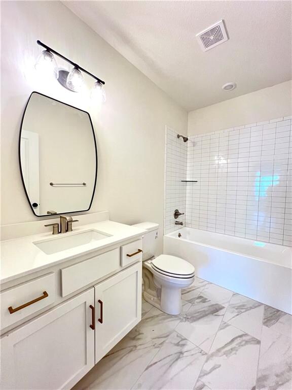 full bathroom featuring vanity, toilet, and tiled shower / bath