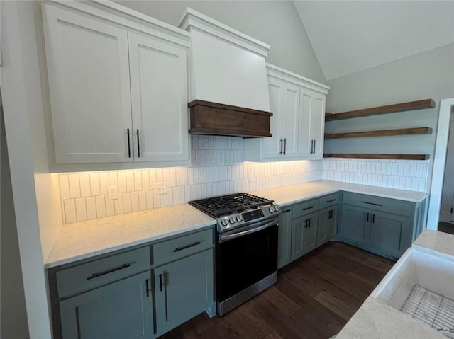 kitchen with dark wood finished floors, custom exhaust hood, open shelves, lofted ceiling, and gas range