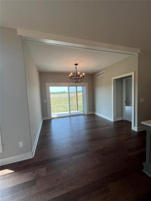 unfurnished room with dark wood-style flooring, visible vents, baseboards, and an inviting chandelier