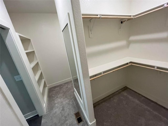 spacious closet featuring visible vents and dark carpet