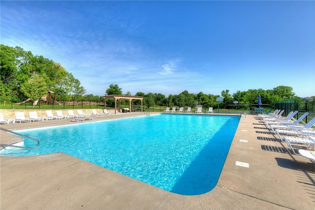 community pool featuring fence, a pergola, and a patio