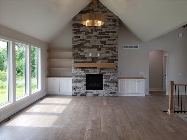 4576 Aspen Dr, Basehor, KS 66007 - unfurnished living room featuring high vaulted ceiling, light wood finished floors, arched walkways, and a fireplace