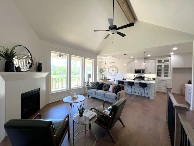 living room featuring sink, ceiling fan, high vaulted ceiling, wood-type flooring, and beamed ceiling