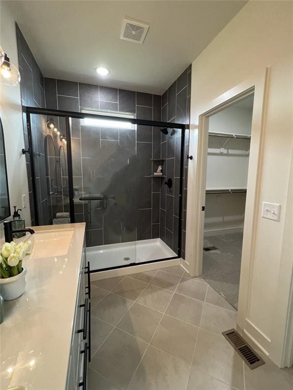 bathroom featuring vanity, tile patterned flooring, and a shower with shower door