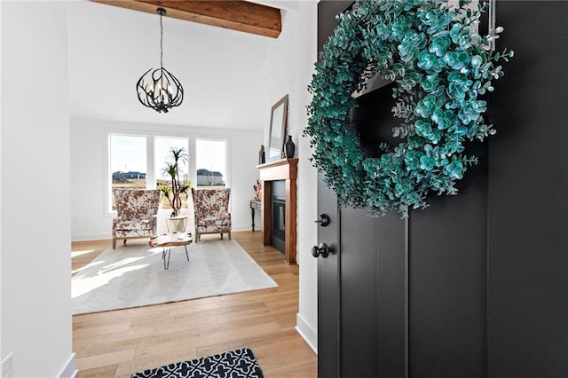 entrance foyer featuring beamed ceiling, hardwood / wood-style flooring, a notable chandelier, and high vaulted ceiling