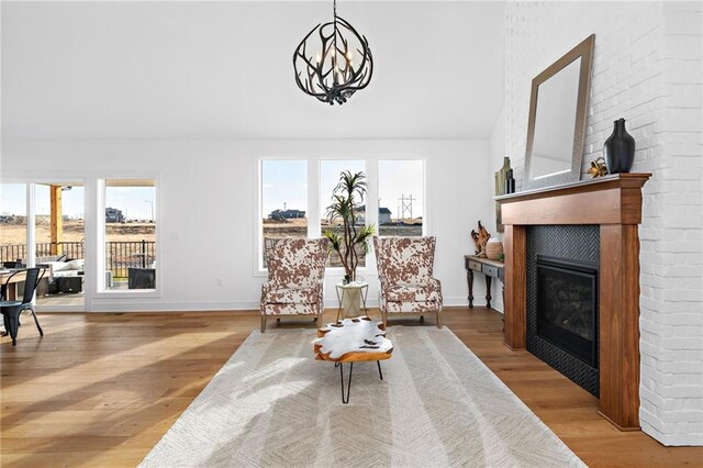 living area featuring a tile fireplace, a chandelier, and light hardwood / wood-style flooring