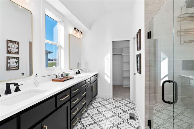 bathroom with vaulted ceiling, vanity, and a shower with door