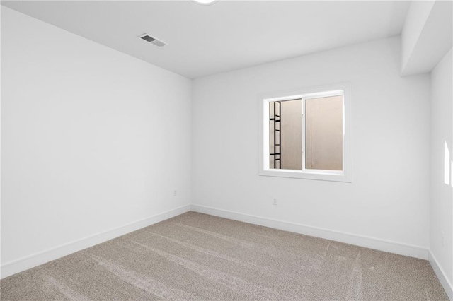 empty room featuring carpet floors, visible vents, and baseboards