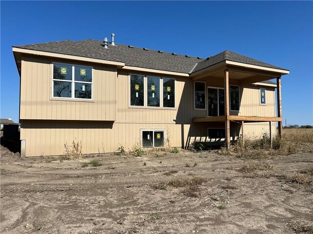 rear view of property featuring roof with shingles
