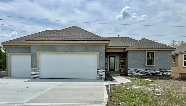 view of front of property with driveway, an attached garage, stucco siding, stone siding, and roof with shingles