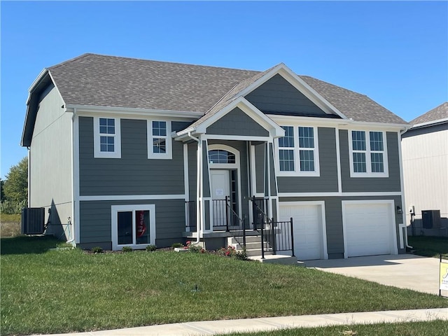 raised ranch with a front yard, cooling unit, and a garage