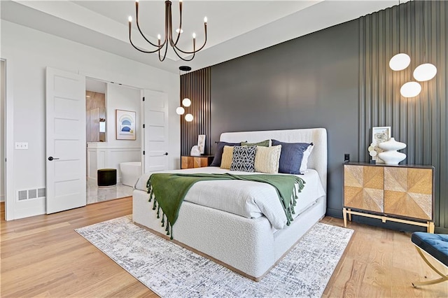 bedroom with wood-type flooring and a notable chandelier