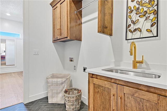 laundry room featuring cabinets, sink, hookup for a washing machine, dark hardwood / wood-style floors, and hookup for an electric dryer