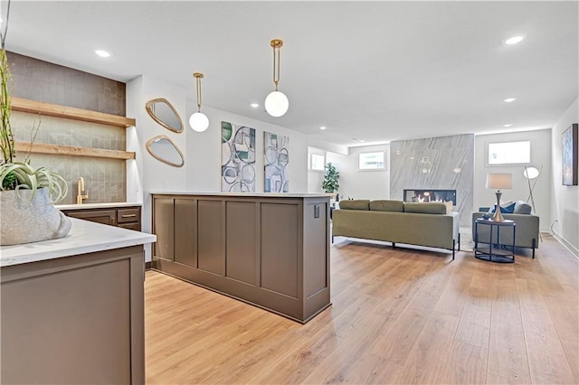 kitchen featuring light wood-type flooring, decorative light fixtures, and sink